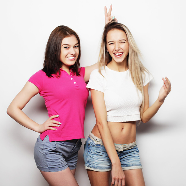 Two young girl friends standing together and having fun. - Photo, Image