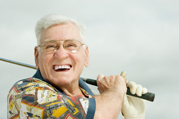 Vanhempi mies pelaamassa golfia
 - Valokuva, kuva