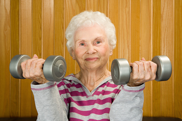 Mujer mayor levantando pesas
 - Foto, imagen