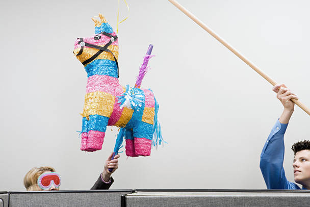 Trabajadores de oficina jugando con una piñata
 - Foto, Imagen