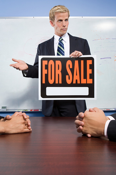 Homme d'affaires tenant à vendre signe
 - Photo, image