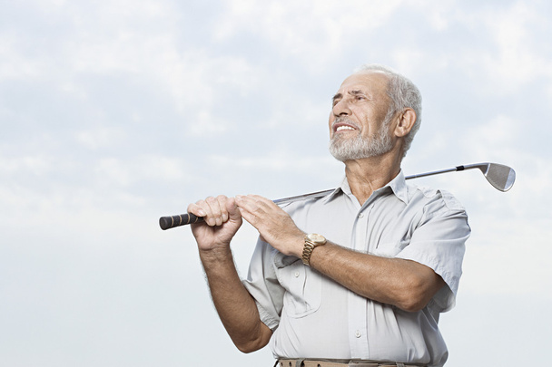 Чоловік тримає гольф клуб
 - Фото, зображення