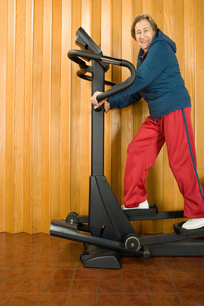 Senior woman walking on a treadmill - Photo, Image