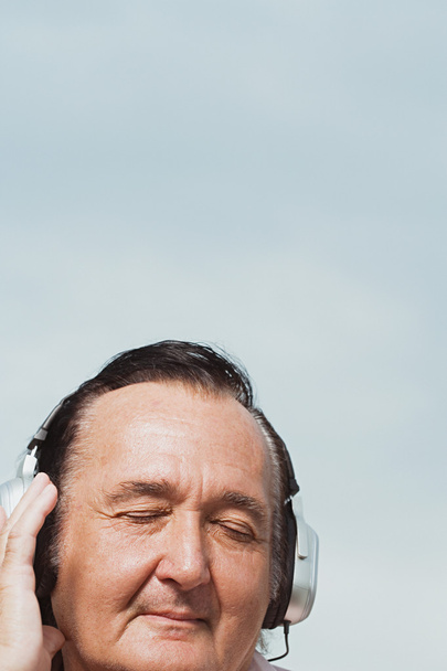 starszy mężczyzna słuchania słuchawki - Zdjęcie, obraz