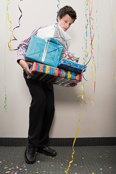 Businessman struggling with pile of presents - Photo, Image