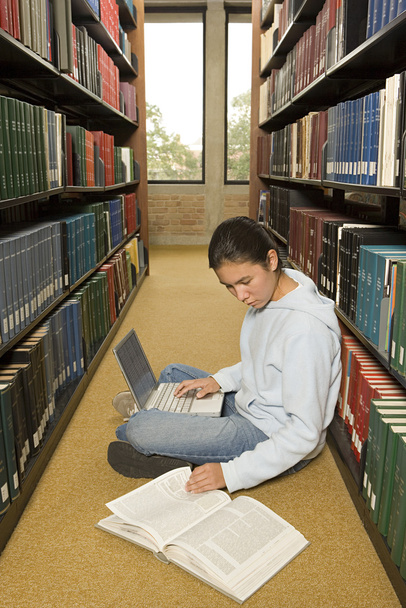 női hallgató dolgozik a könyvtárban - Fotó, kép