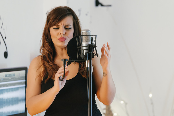 Beautiful young singer singing in direct - Foto, Bild