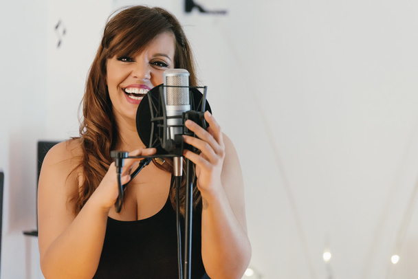 Beautiful young singer singing in direct - Photo, image