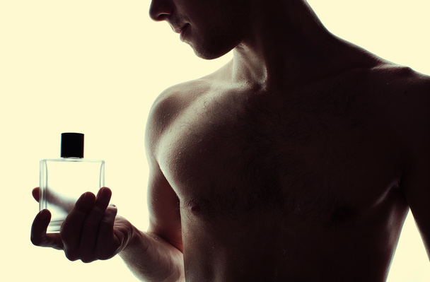 Hombre musculoso guapo con frasco de perfume
  - Foto, imagen