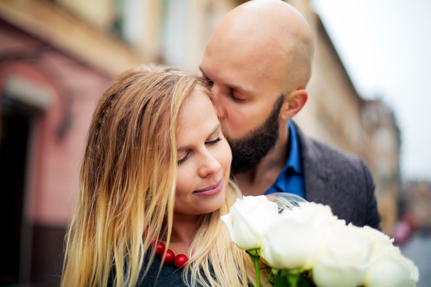 A picture of a couple happy on Valentine's Day with flowers, kisses her - Foto, Bild