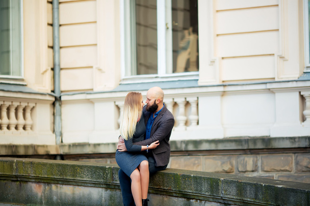 One beautiful stylish emotional couple of young woman and senior man with long black beard embracing sitting close to each other - Φωτογραφία, εικόνα