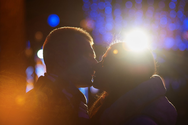Gelukkige paar kussen op de achtergrond van de illuminations en bokeh - Foto, afbeelding