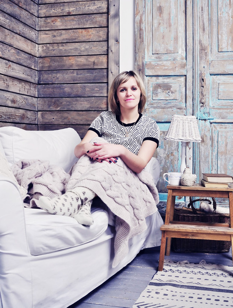 Frau liegt auf Couch im Wohnzimmer im rustikalen Stil - Foto, Bild