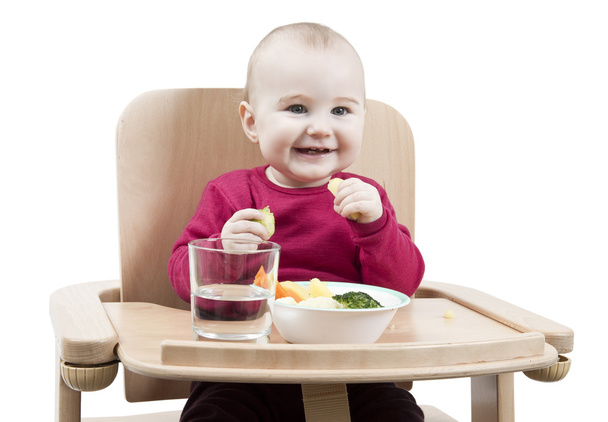Jeune enfant mangeant en chaise haute
 - Photo, image