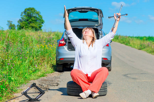 kırık araba yakınındaki direksiyonda oturan kadın sürücü dua - Fotoğraf, Görsel