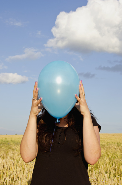 Young woman holding azure balloon - Fotó, kép