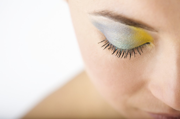 vrouw draagt blauwe en gele oogschaduw - Foto, afbeelding