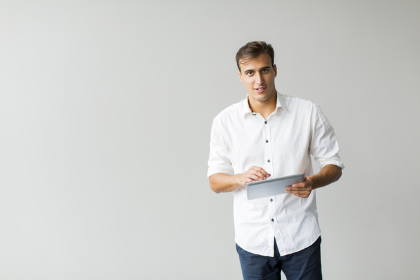 Hombre con tableta junto a la pared
 - Foto, imagen