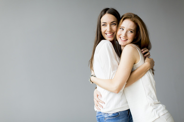 Abrazando amigos sobre fondo gris
 - Foto, imagen