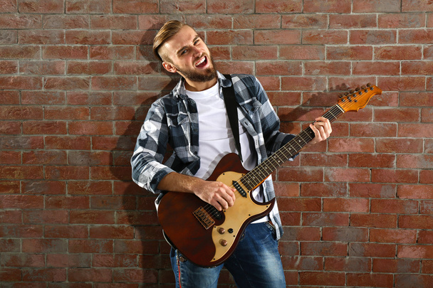Young man playing guitar - Fotó, kép