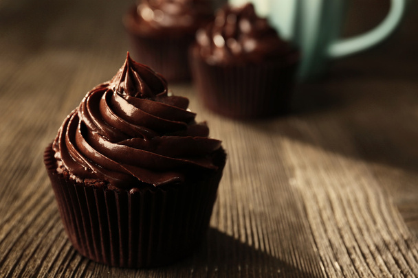 Chocolate cupcakes served with a drink on wooden table - Foto, afbeelding