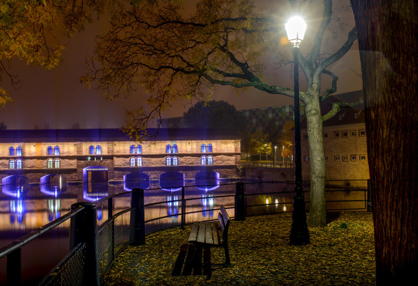 Éjszaka a Strasbourg városközpontjában, a sétány magányos padon, az őszi fények városában - Fotó, kép
