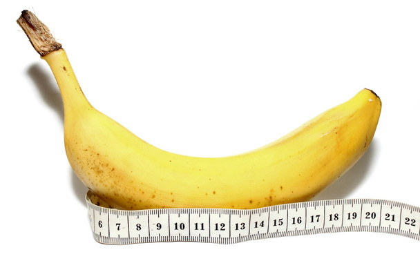 Nagy banán és mérőszalag elkülönített fehér alapon, mint a férfi nagy pénisz - Fotó, kép