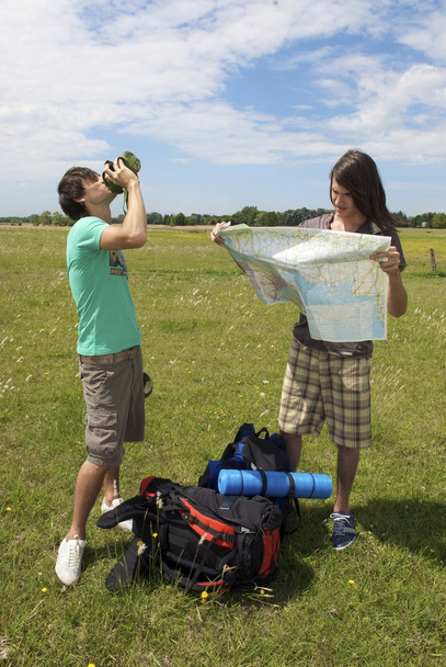 backpackers drinking water on meadow - Photo, Image