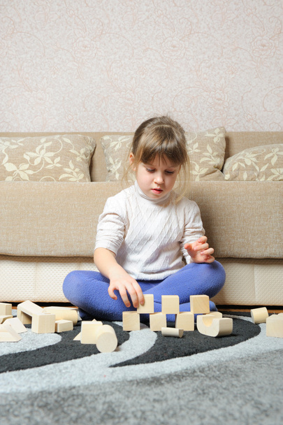 The little girl plays wooden toy cubes - 写真・画像