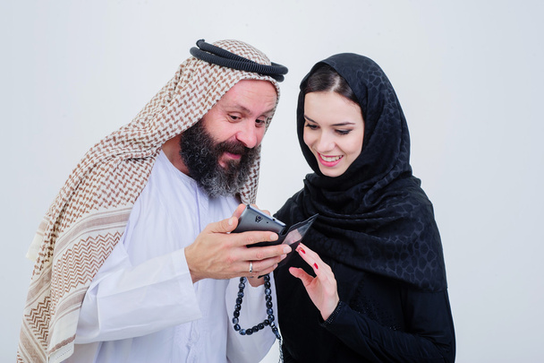 Portrait of Arabic way dressed couple play with mobile phone. - Photo, Image