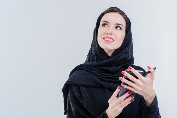 Mujer árabe bastante moderna jugando en el teléfono inteligente
. - Foto, imagen