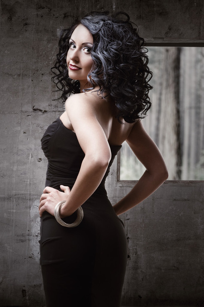 Beautiful woman wearing black dress posing indoors - Valokuva, kuva