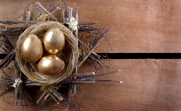Three golden eggs in a nest - Foto, Imagen
