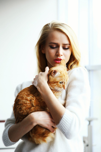 Woman holds red cat in hands - Фото, зображення
