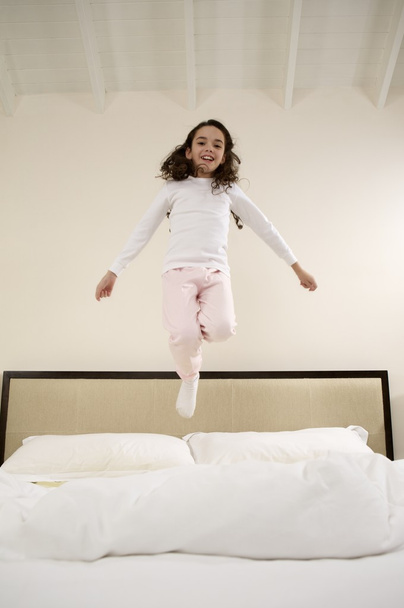 Kleines Mädchen springt auf Bett - Foto, Bild