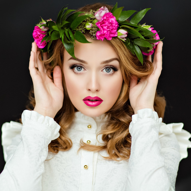 Portrait of a beautiful sensual glamorous yellow-haired girl in a white blouse with a wreath of flowers on his head, in the Studio on a dark background, close up - Foto, Bild