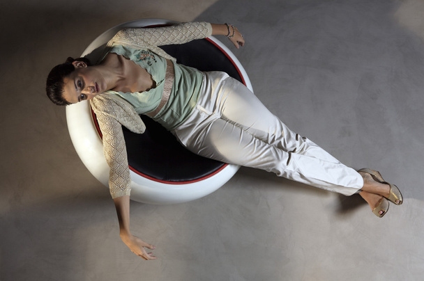 Beautiful Woman lying down on round chair - Fotoğraf, Görsel