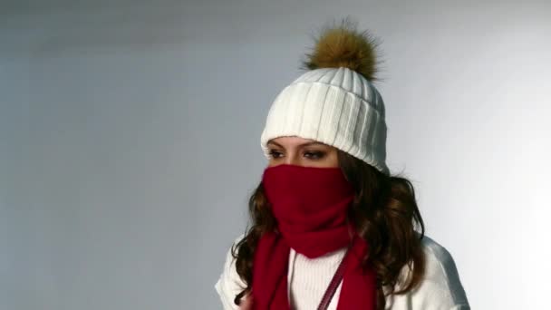Beautiful girl coughs in winter hat - Filmati, video