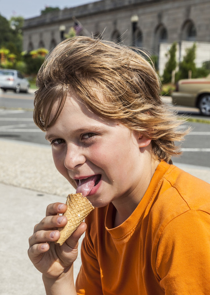 Nuori poika syö maukasta jäätelöä
  - Valokuva, kuva