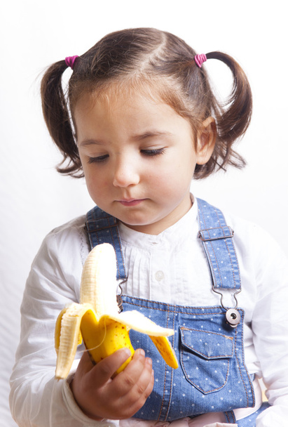 Portrait of happy girl holding a banana - Foto, afbeelding