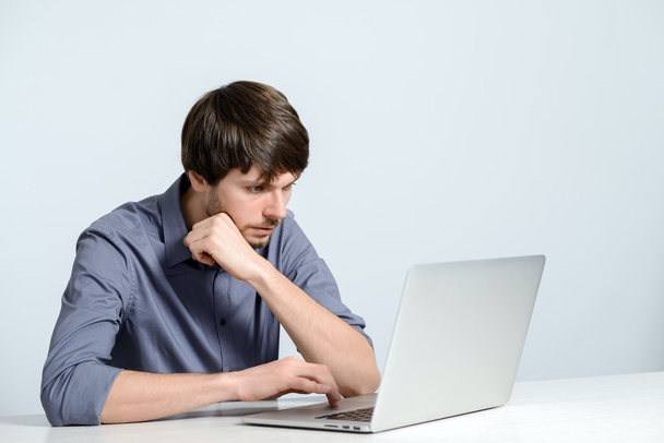 молодий чоловік працює на ноутбуці
 - Фото, зображення