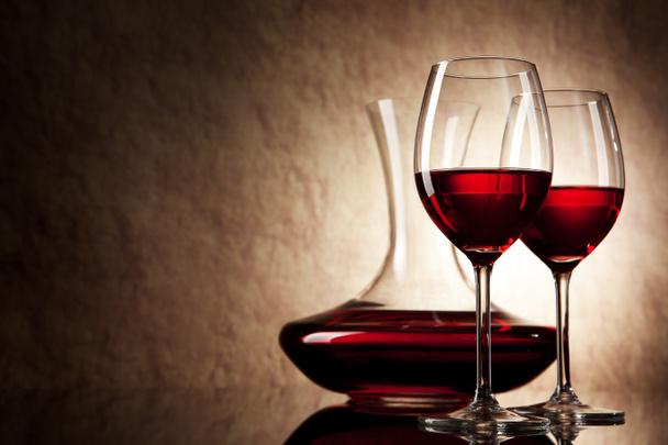 Decanter with red wine and glass on a old stone background - Photo, Image