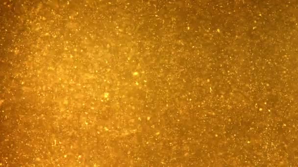 Partículas brillantes que fluyen en líquido amarillo oscuro
 - Imágenes, Vídeo