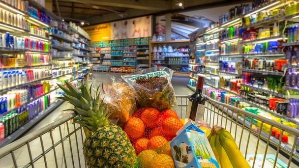 Trolley in supermarket with food products - Photo, Image