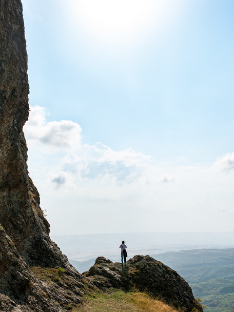 uomo sul ciglio di una scogliera in montagna
 - Foto, immagini
