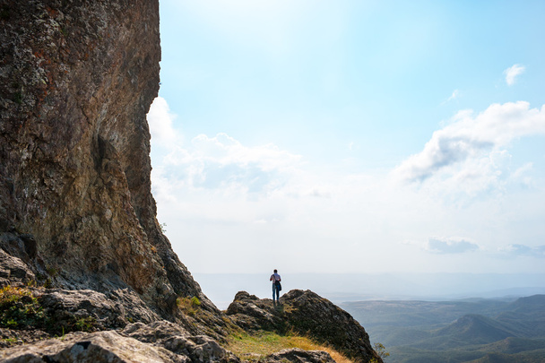 Mann am Rande einer Klippe in den Bergen - Foto, Bild