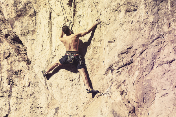 Man climbing a mountain wall. - Zdjęcie, obraz