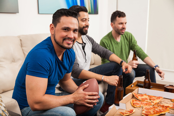 Hispanic men watching an american football - 写真・画像