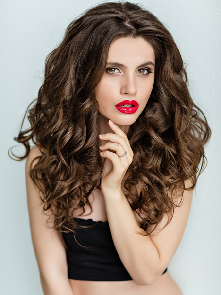 Portrait of a beautiful glamorous brunette with curly hair and b - Фото, изображение