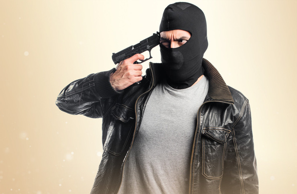 Ladrón disparando con una pistola
 - Foto, Imagen